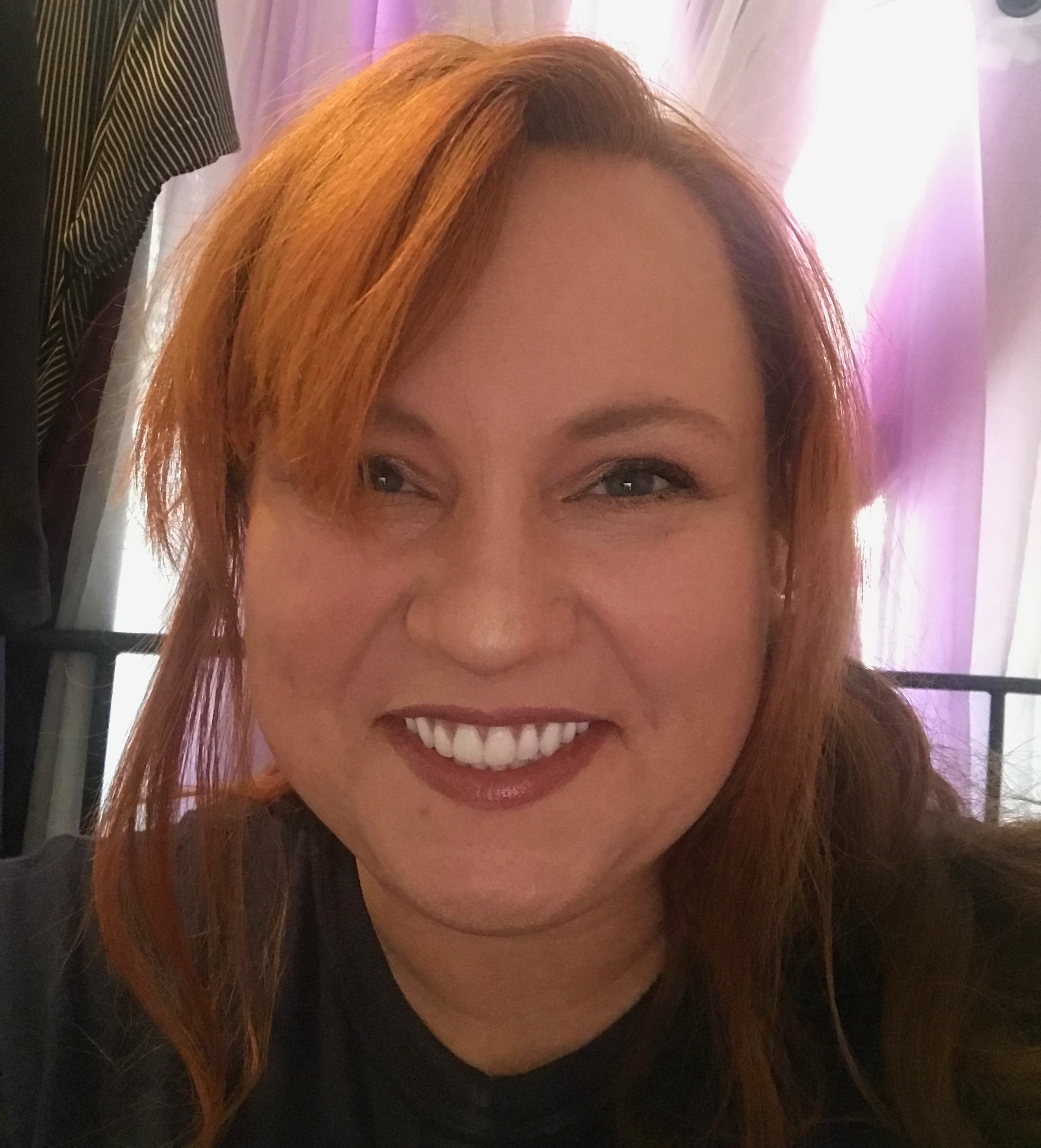 Laurie has red hair, white teeth, and a fierce double chin.